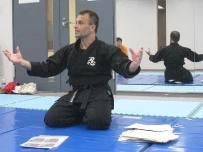 マットに座り、両腕を開いて説明するジェローム・パイエット。