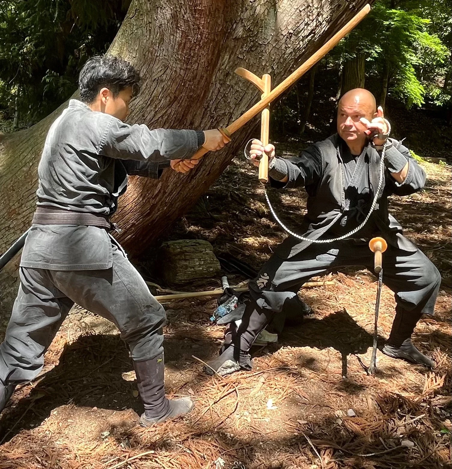 低く構えた稽古者が、相手の木刀に向けて道具を装着した両手を出している。