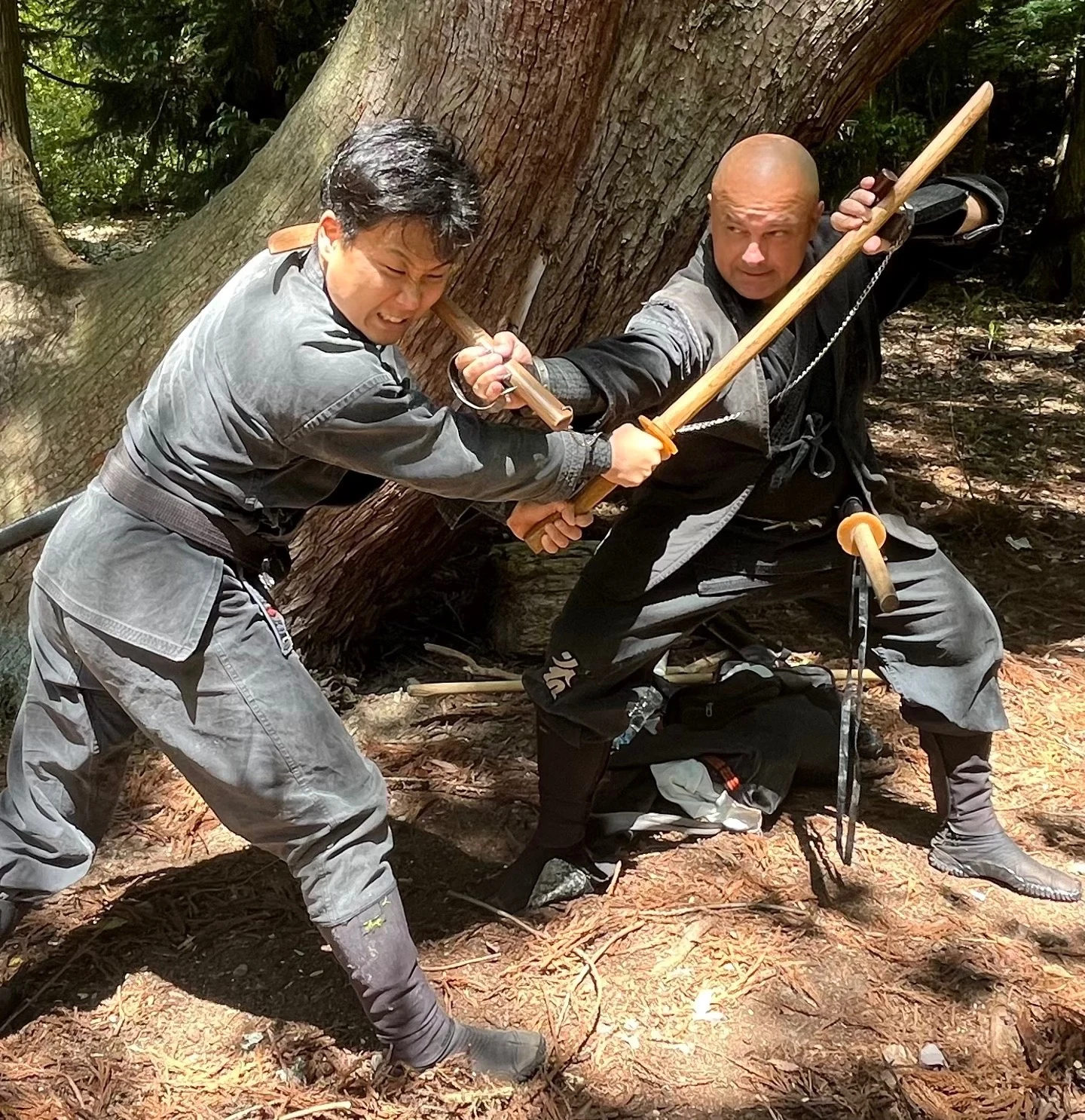 二人が木刀を挟んで近づき、腕を接触させて稽古している。